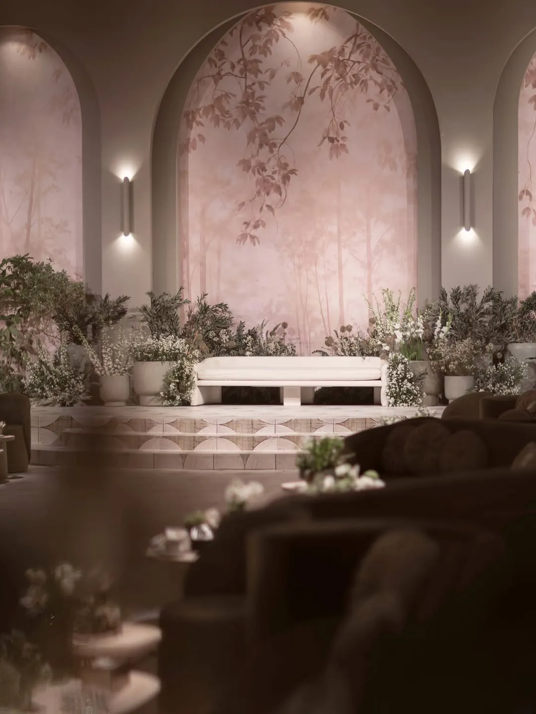 Arched stage backdrop with painted foliage, wall lights and a white sofa